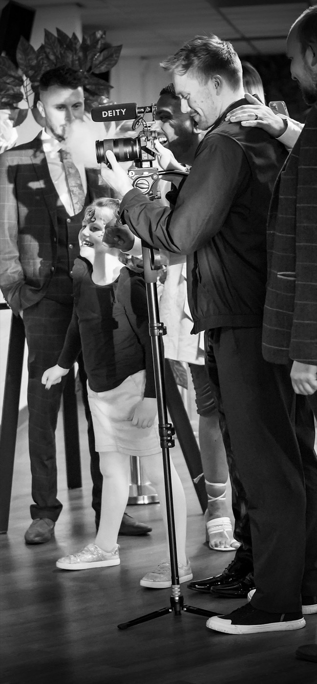 Dan filming discreetly among guests at a wedding reception