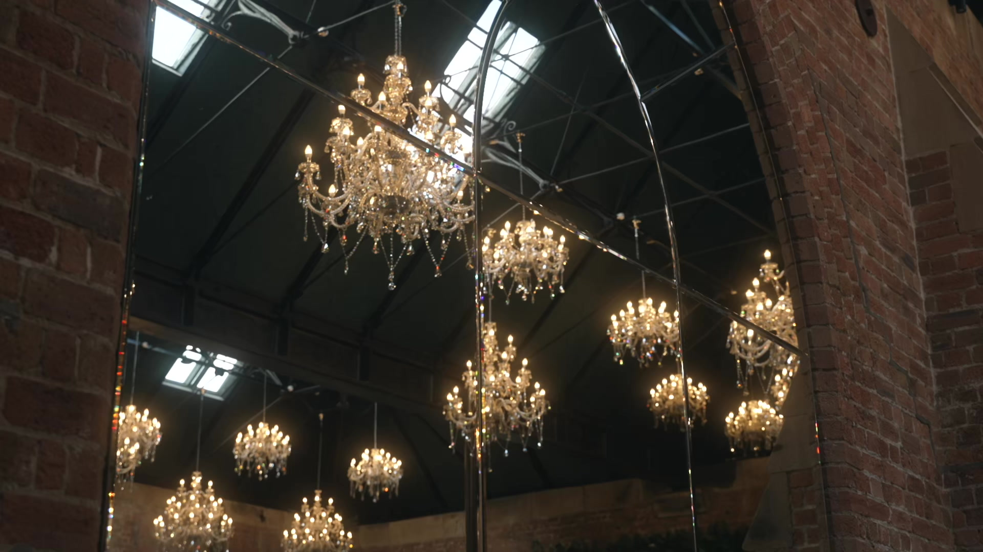 Chandeliers glowing inside a barn wedding venue